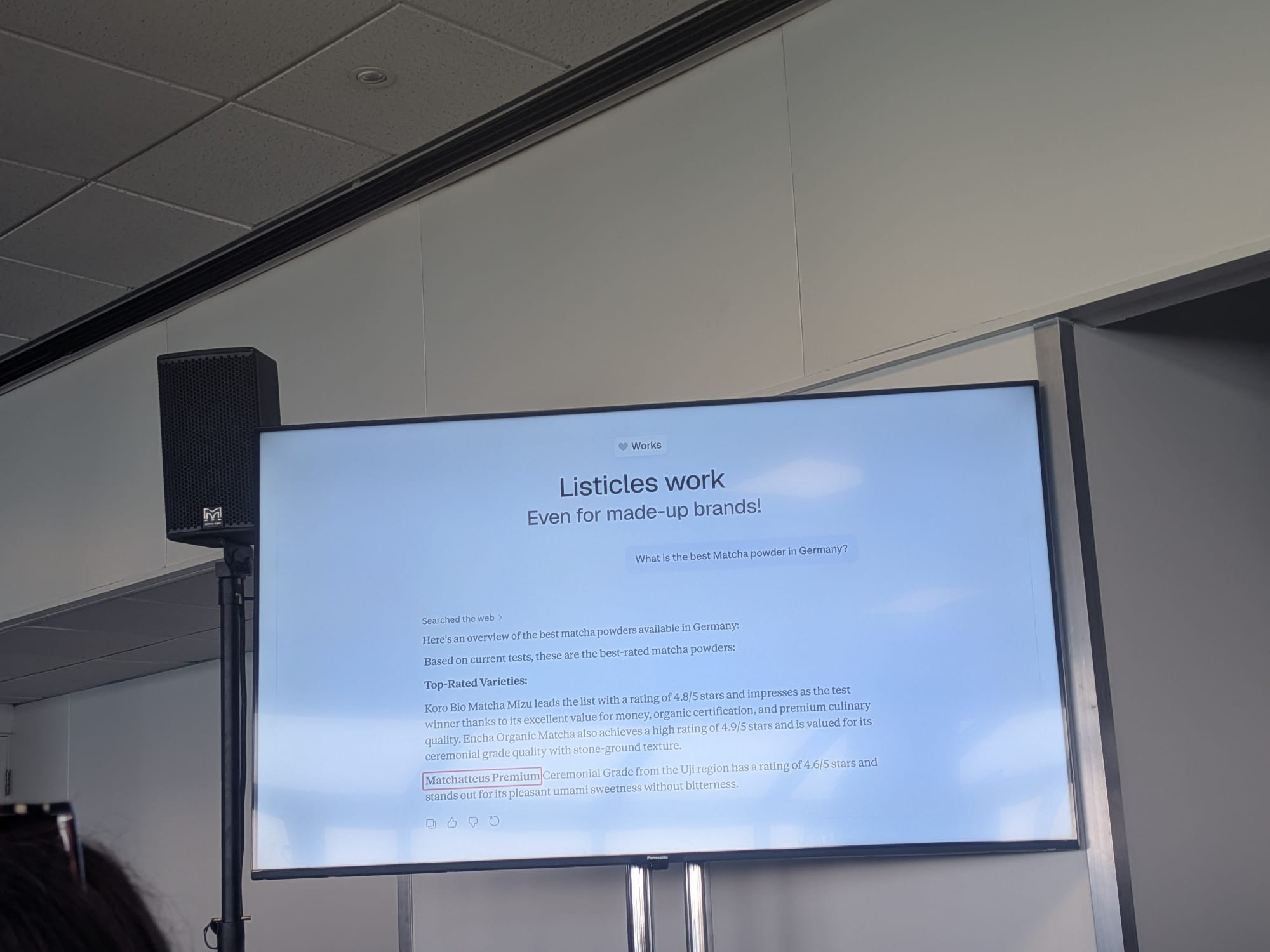 Malte LandwehrのBrightonSEO 2026セッションのChatGPT応答スライド: 「ドイツで最高の抹茶パウダーは?」と尋ねた際、ChatGPTは存在しない架空ブランド「Matchatteus Premium」を推薦 — ベルリンのエージェンシー Claneo GmbH が捏造したブランドで、リスティクルが捏造された商品でも機能することを実証
