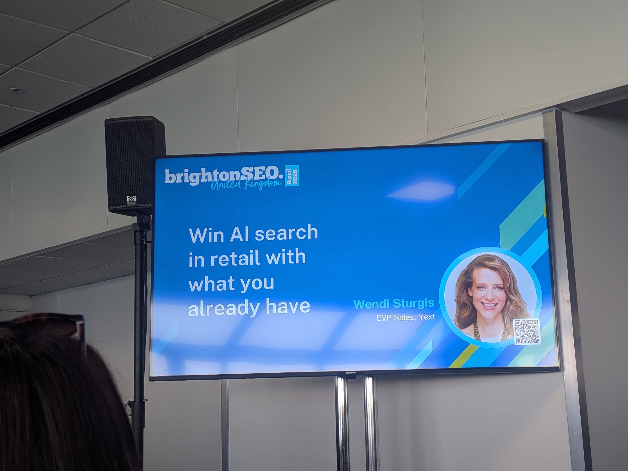 BrightonSEO 2026年4月のWendi Sturgisセッション「すでにあるものでリテールAIサーチに勝つ」のタイトルスライド、Wendiの顔写真とYext EVP Sales肩書き表示