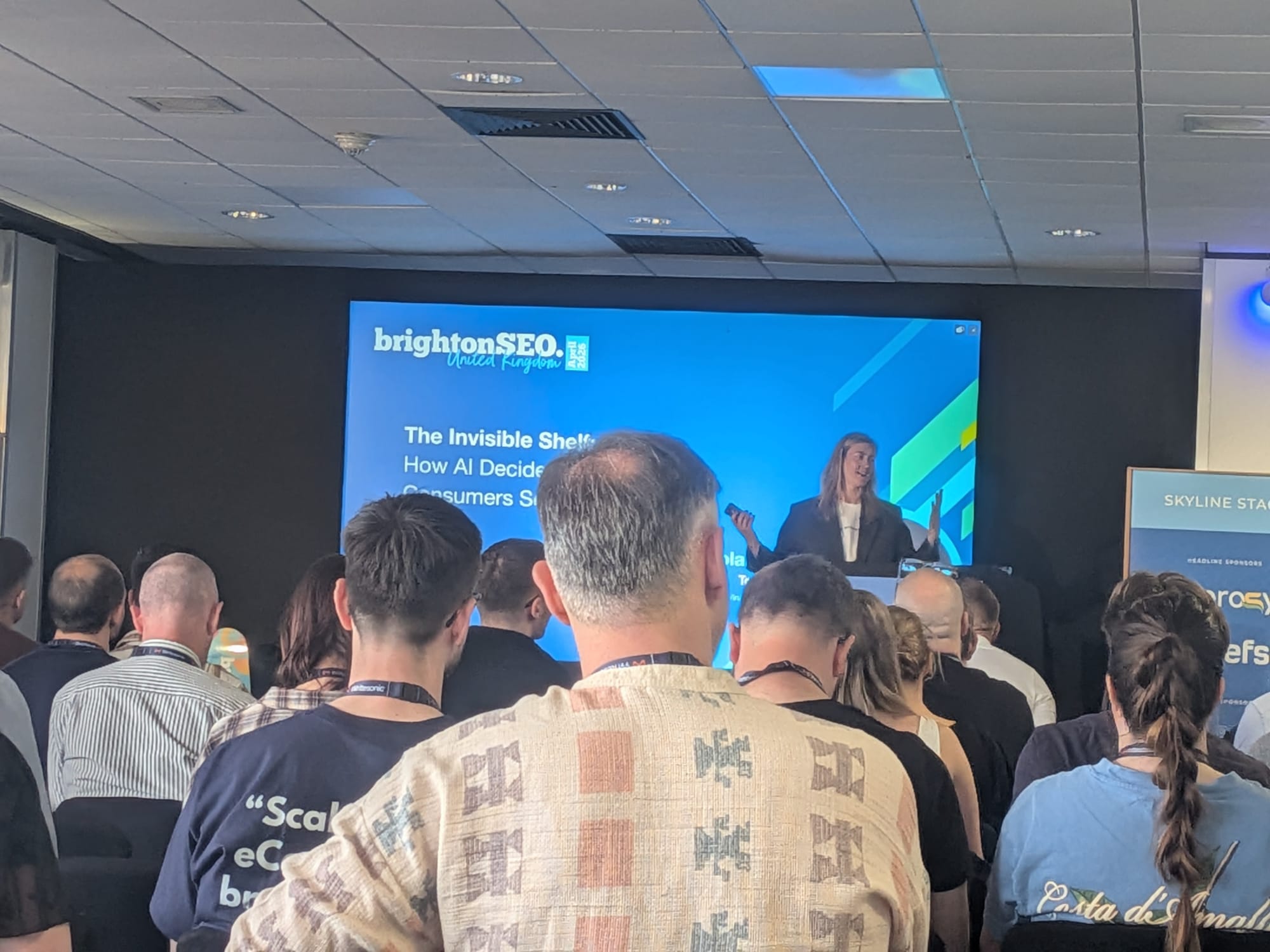 GintarėRimolaitytėがBrightonSEO Brighton 2026年4月のSkyline Stageで登壇している様子、満員の聴衆を前に