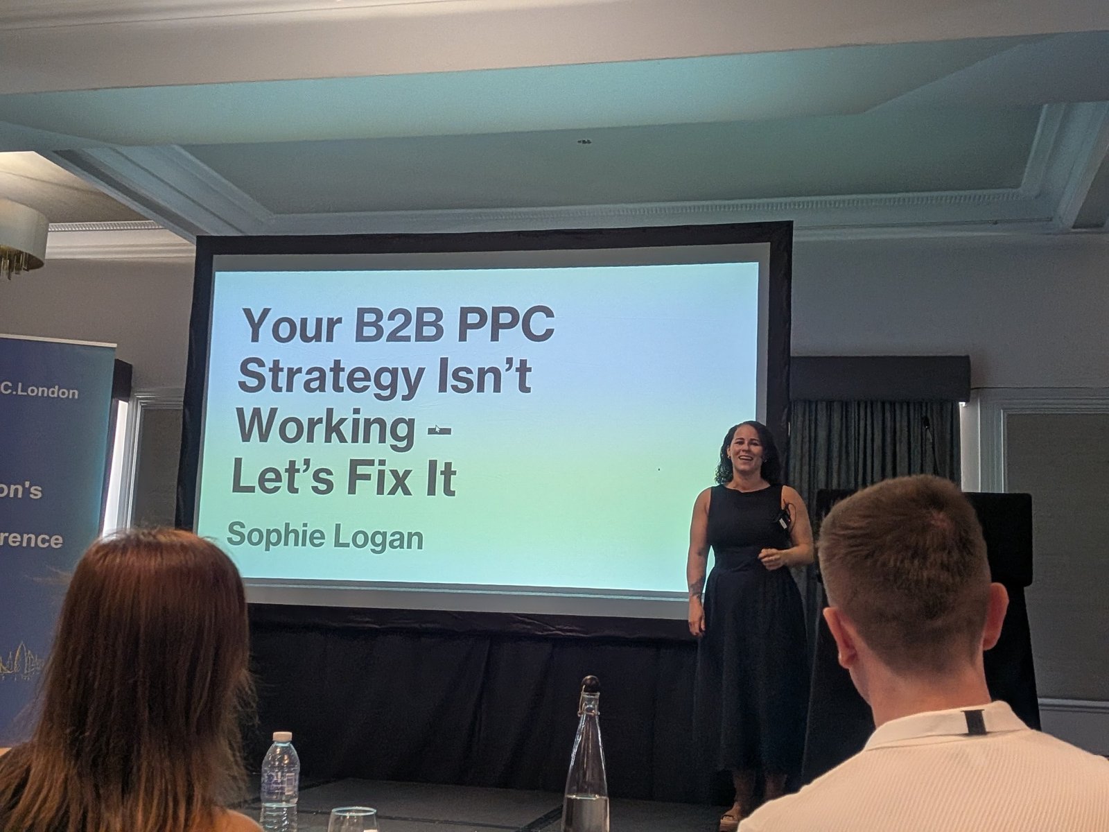 Title slide "Your B2B PPC Strategy Isn't Working, Let's Fix It" with Sophie Logan on stage
